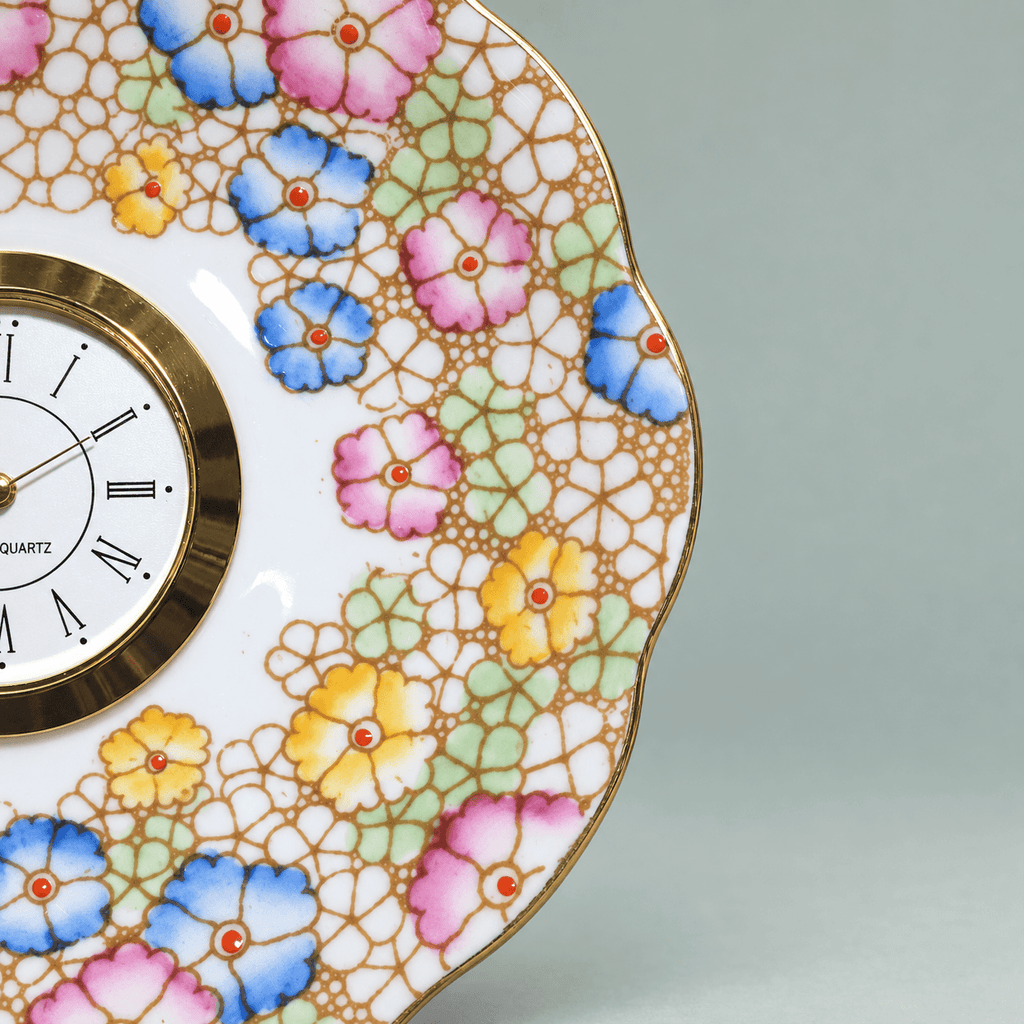 Pastel mosaic china plate clock with pink, blue and yellow flowers, mint-green accents and a gold Roman numeral clock face