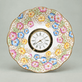 Pastel mosaic china plate clock with pink, blue and yellow flowers, mint-green accents and a gold Roman numeral clock face