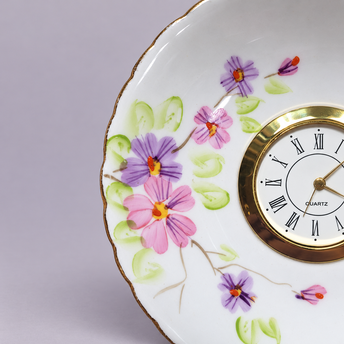 Close-up of the lavender floral plate clock with its gold-tone Roman numeral clock face