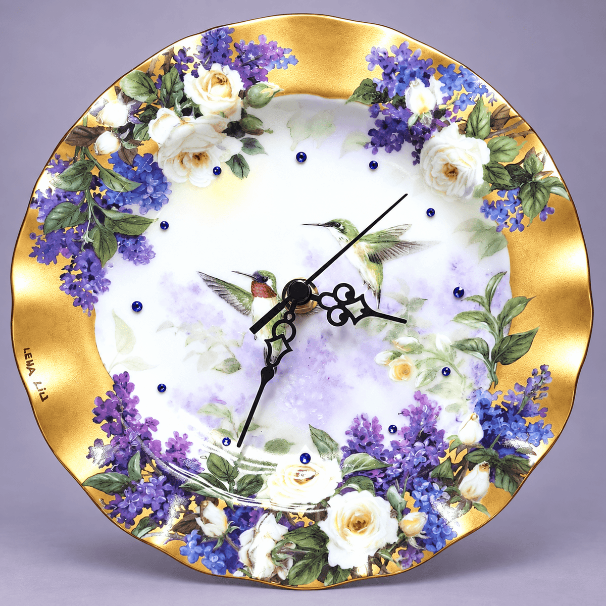 Hummingbird decorative plate clock with two hummingbirds, purple lilacs, ivory roses and sapphire-blue crystal hour markers